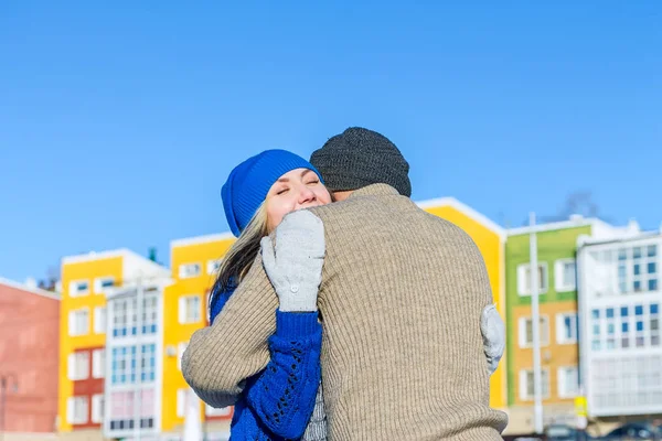 Junges Paar umarmt und küsst Hintergrund farbigen Häusern — Stockfoto