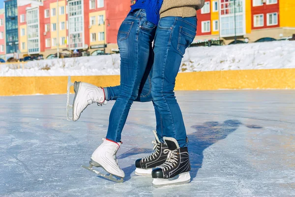 Die Beine in Schlittschuhen auf Eis umarmendes Paar — Stockfoto