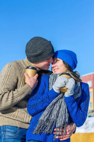 Paar im Winterpulli umarmt Tassen Kaffee — Stockfoto