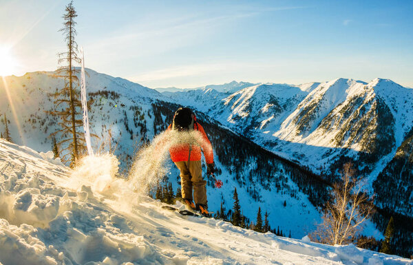 Freerider skier descends from the mountain in the light of the m