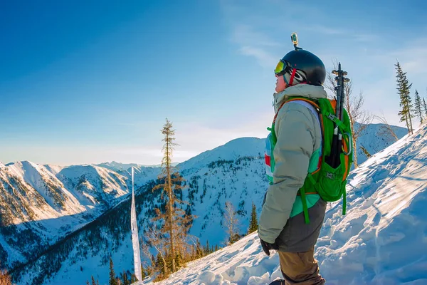 Freeride snowboarder se encuentra en la ladera bajo el sol del amanecer — Foto de Stock