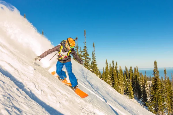 Freeride snowboardåkare bilder ner en brant sluttning i gryningen — Stockfoto