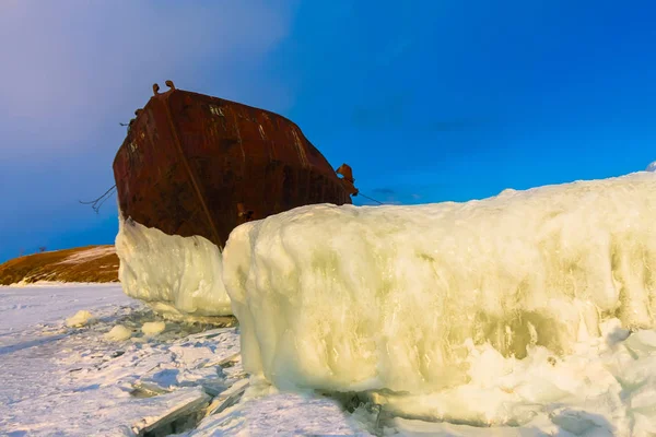 Old rusty ship on ice covered sunset standing on the shore — Stock Photo, Image