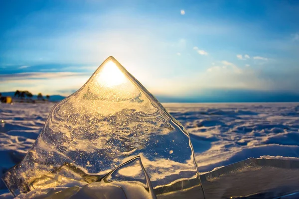 Sun at sunset shining through the transparent texture of the ice — Stock Photo, Image