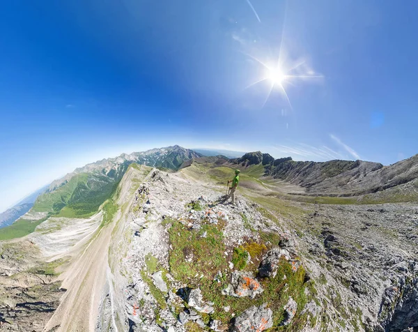 Szerokokątna antena panorama człowiek stoi na górze w górach — Zdjęcie stockowe