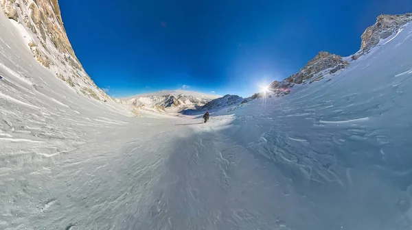 Vista de grande ângulo de um caminhante de montanha para escalar uma montanha de neve — Fotografia de Stock