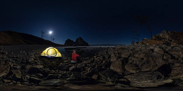 Spherical panorama 360 180 of man at tent on stone beach on shor