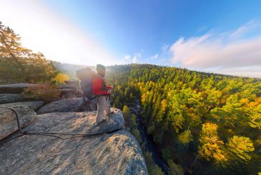 Backpacker bir kaya üzerine düşmek şafakta. Geniş açı hava panorama