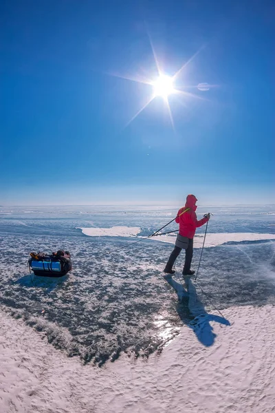 Turista con slitte passeggiate lungo il ghiaccio blu del lago Baikal — Foto Stock