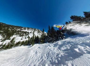 Snowboard freerider kar rampa atlayarak. Geniş açı hava panorama