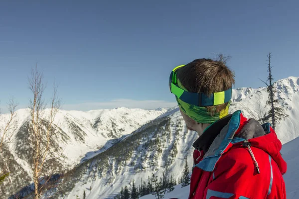 Retrato joven hombre gafas de esquí mira a las montañas — Foto de Stock