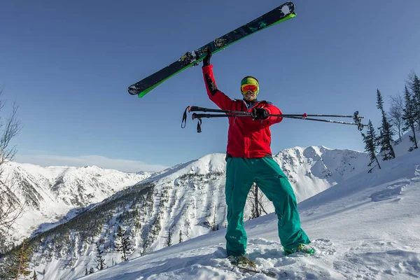 Retrato joven hombre gafas de esquí celebración de esquí en las montañas — Foto de Stock