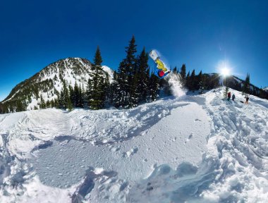 Snowboard freerider kar rampa atlayarak. Geniş açı hava panorama