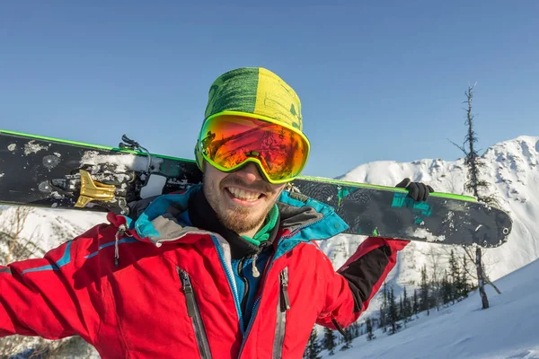 Portrait young man ski goggles holding ski in the mountains — Stock Photo, Image