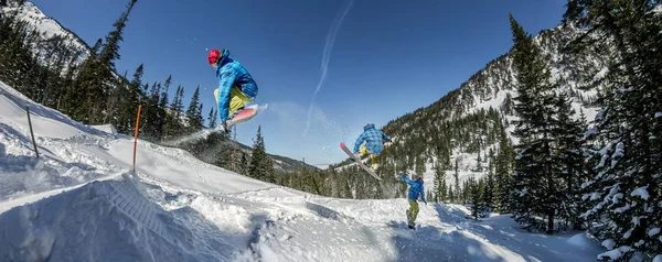 Panorama snowboard freerider orman ve dağlar bir arka plan üzerinde bir kar rampa güneşin üzerinden atlama