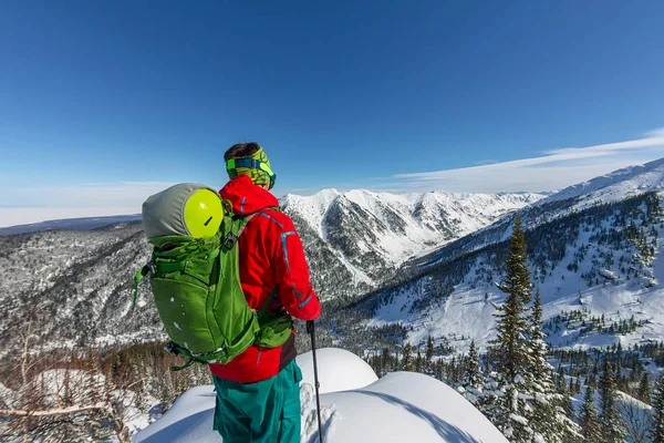 Un hombre parado en la cima de la cresta. Esquí de montaña. Aventura invierno freeride deporte extremo — Foto de Stock