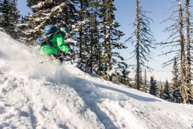 Kadın kayakçı ile dağlara toz kar üzerinden gidiyor. Kış sporları freeride