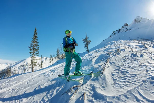 Hombre esquiador freerider de pie en la cima de la cresta, aventura invierno freeride deporte extremo — Foto de Stock