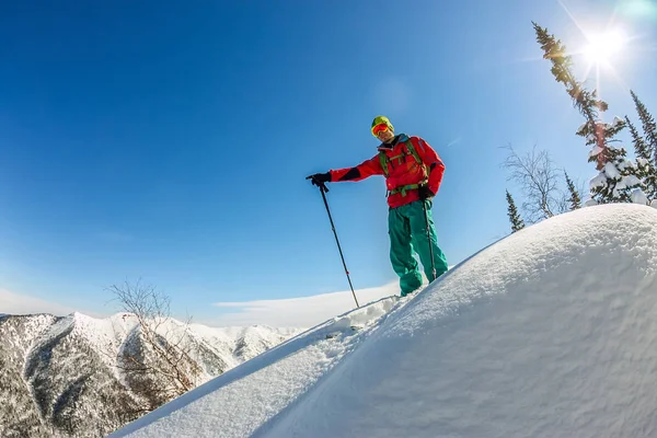 Un hombre parado en la cima de la cresta. Esquí de montaña. Aventura invierno freeride deporte extremo — Foto de Stock