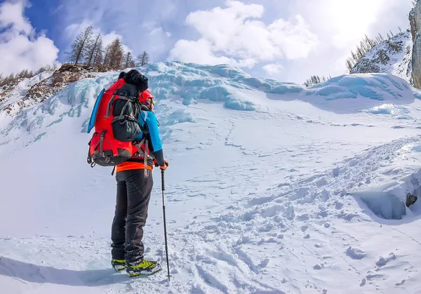 Kvinnlig bergsbestigare med ryggsäck, hjälm och sele med klättring i berg — Stockfoto