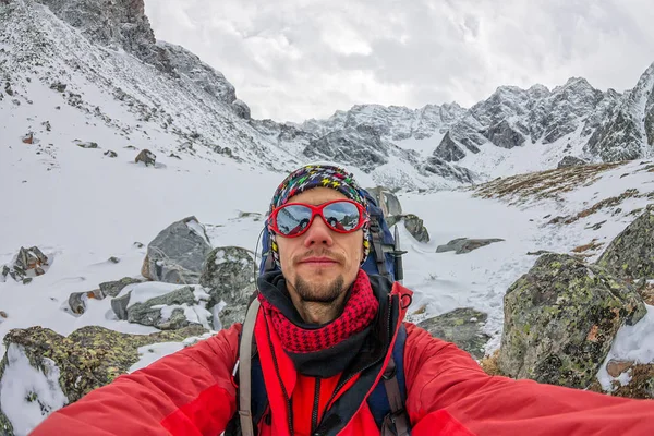 Selfi mannelijke klimmer in de besneeuwde bergen — Stockfoto