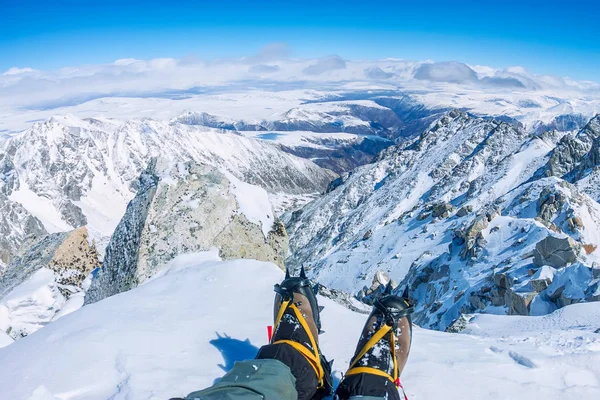 アイゼンで足に最初の人のビューは、山の上に休息を取る — ストック写真