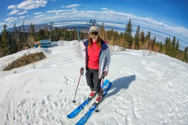 gökyüzüne karşı karlı yolda Alp disiplini üzerine genç kız duruyor