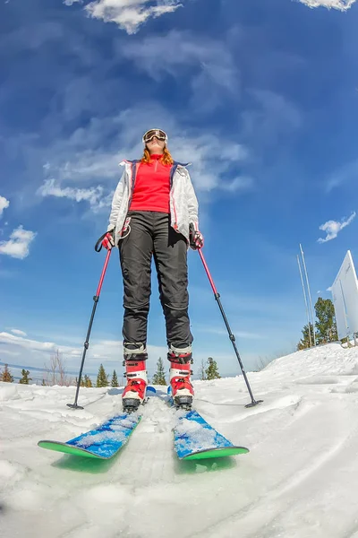 Ung flicka på Alpin skidåkning står på en snöig väg mot himlen — Stockfoto