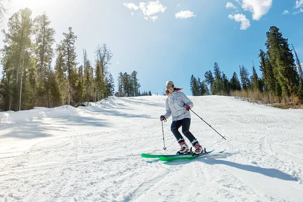 Ung flicka på Alpin skidåkning på en snöig väg mot himlen — Stockfoto