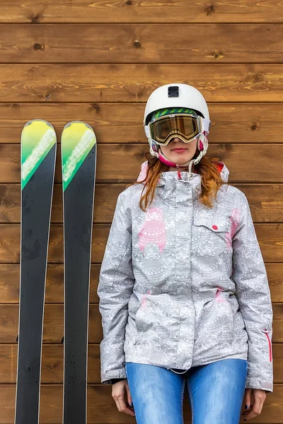 Portret kobiety narciarz narty i kask w pobliżu ściany drewniane — Zdjęcie stockowe