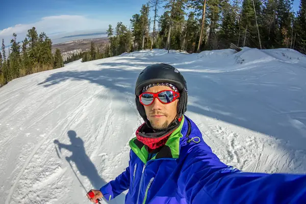 Hombre esquiador tomando foto selfie con la cámara del teléfono celular inteligente — Foto de Stock