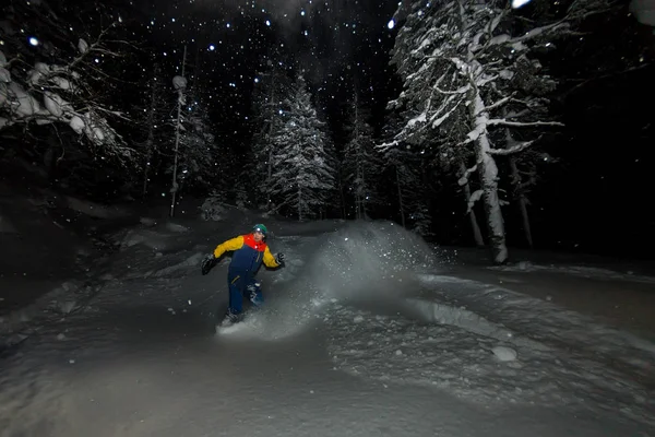 Freerider cabalga por la noche sobre nieve en polvo explota — Foto de Stock