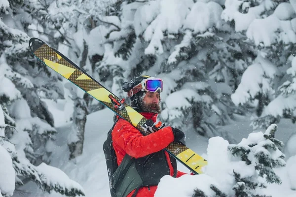 Retrato joven hombre gafas de esquí celebración de esquí en las montañas — Foto de Stock