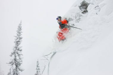 Kayakçı freerider orman ve dağlar bir arka plan üzerinde bir kar rampa güneşin üzerinden atlama