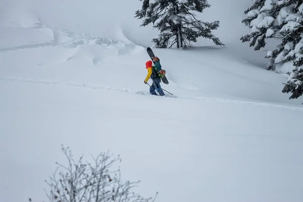 Freerider snowboarder climbs into a snowy mountain — Stock Photo, Image