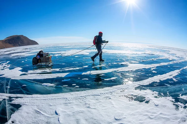 L'uomo con slitta e bastone da trekking è sul ghiaccio del lago Baikal — Foto Stock