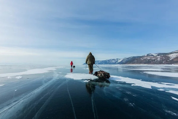 Groep toeristen met ijs sleeën wandelen langs het ijs van het Baikalmeer — Stockfoto