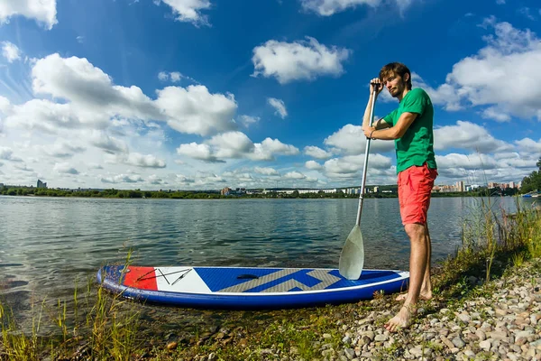 SUP surfing člověk postaví pádlo strávník pádlování na řece při západu slunce — Stock fotografie