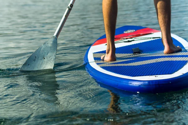 Sup surfing man stand up paddle boarder paddling at sunset on river