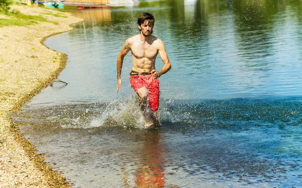 Su ile bir gülümseme ve çıplak bir gövde üzerinde çalışan Koreli genç adam