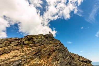 adam sarp bir uçurum gökyüzü arka plan üzerinde duruyor