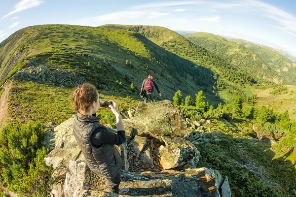 Junges Paar auf einem Felsen in den Bergen fotografiert — Stockfoto