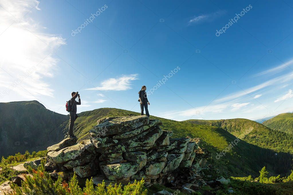 young couple photographed on a rock in the mountains view