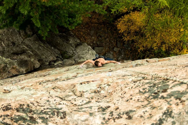 Escalador de roca sube en un acantilado en una cuerda, vista superior — Foto de Stock