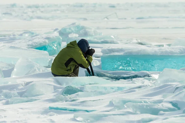 Fotograf pořizuje snímky zamrzlého jasného ledu v zimním jezeře Bajkal, Rusko — Stock fotografie