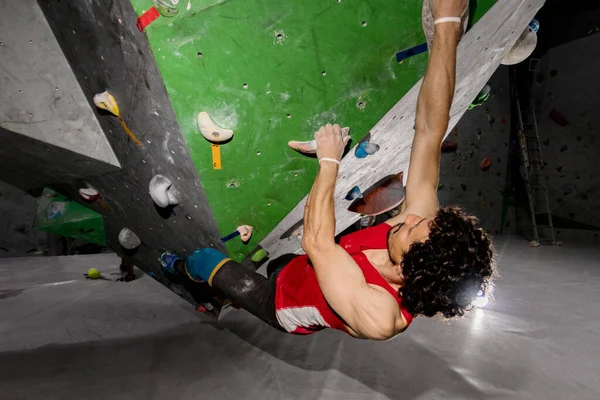 바위 산악인 남자 색된 걸이에 내부 bouldering 등반 벽에 걸려 — 스톡 사진