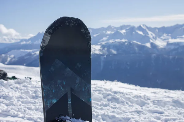 Snowboard se encuentra en el fondo de las montañas nevadas del Cáucaso, la estación de esquí Rosa Khutor —  Fotos de Stock