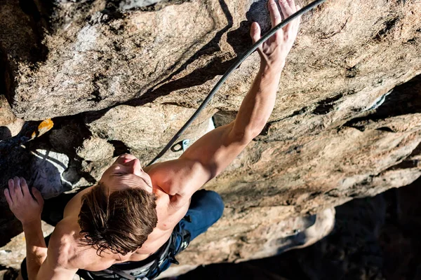 Kletterer mit nacktem Oberkörper klettert auf Felsen mit Top-Versicherung — Stockfoto