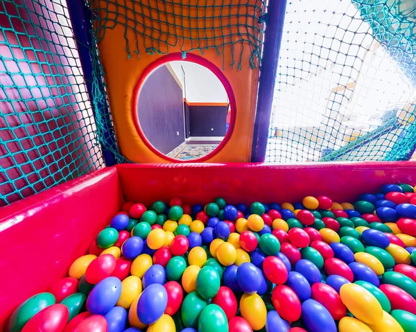 Kinderspeelkamer met kleurrijke ballen en een glijbaan van kunststof. . Breed panorama Stockfoto