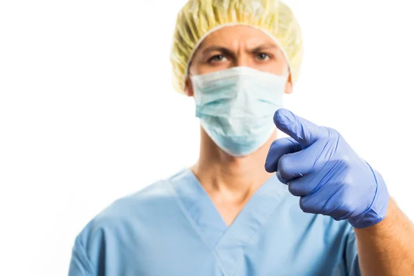 Médico señala el dedo en la ropa médica con guantes de goma y una máscara, retrato sobre un fondo blanco — Foto de Stock